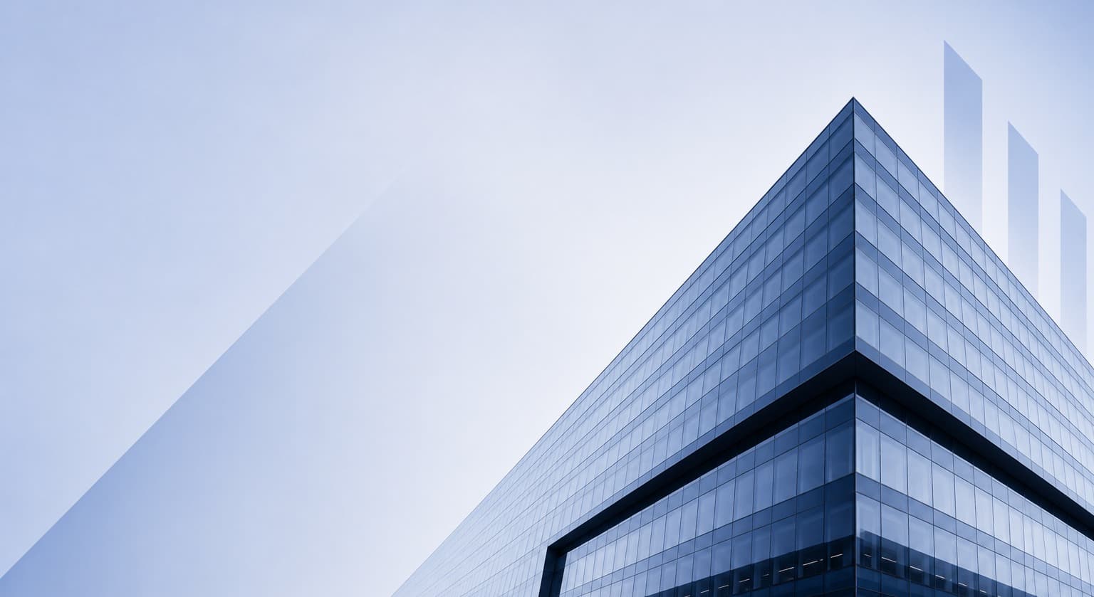 Glass curtain wall facade against a soft sky, with a light architectural skyline motif